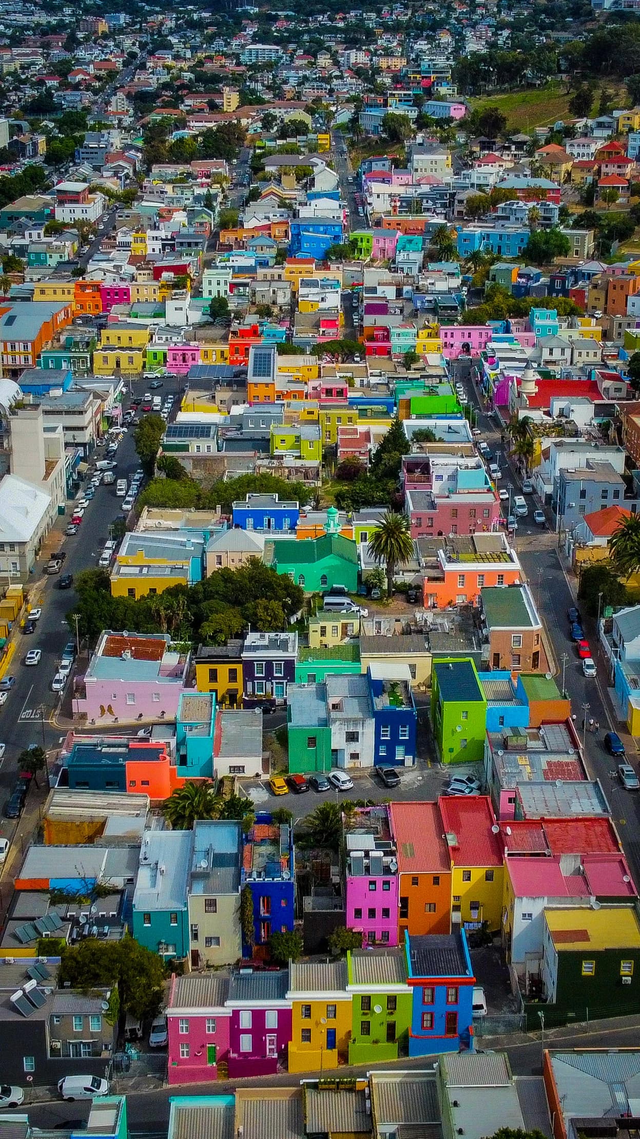 An aerial view of Bo-Kaap’s hillside homes painted vivid pink, turquoise, orange, yellow and green.